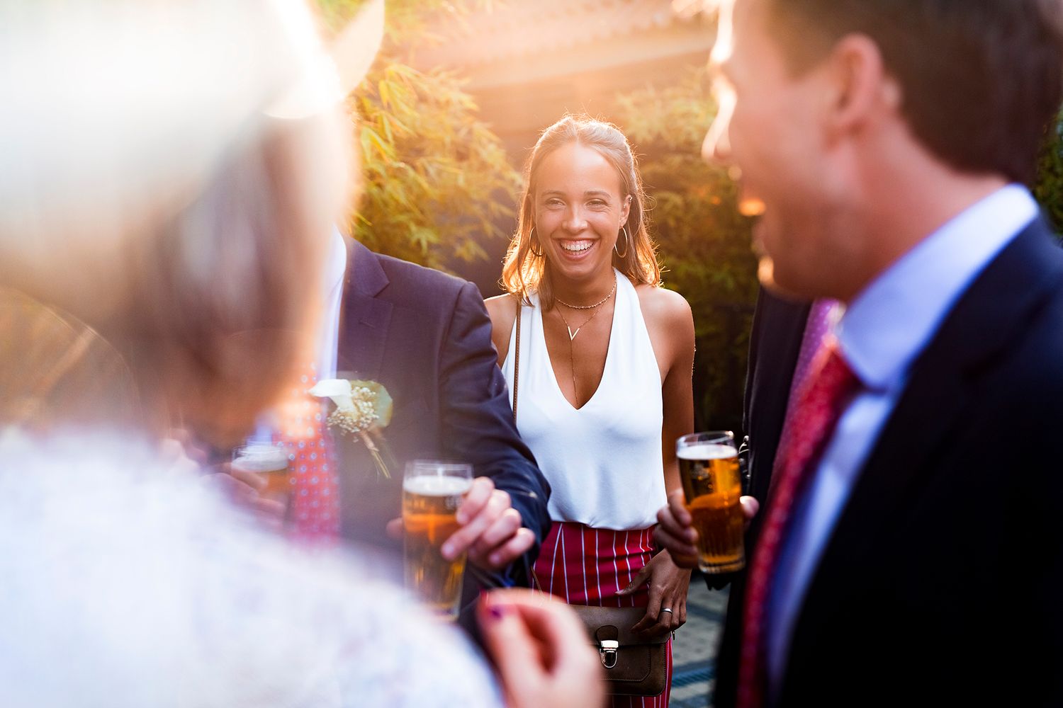 Outdoor social gathering with drinks during golden hour sunlight.