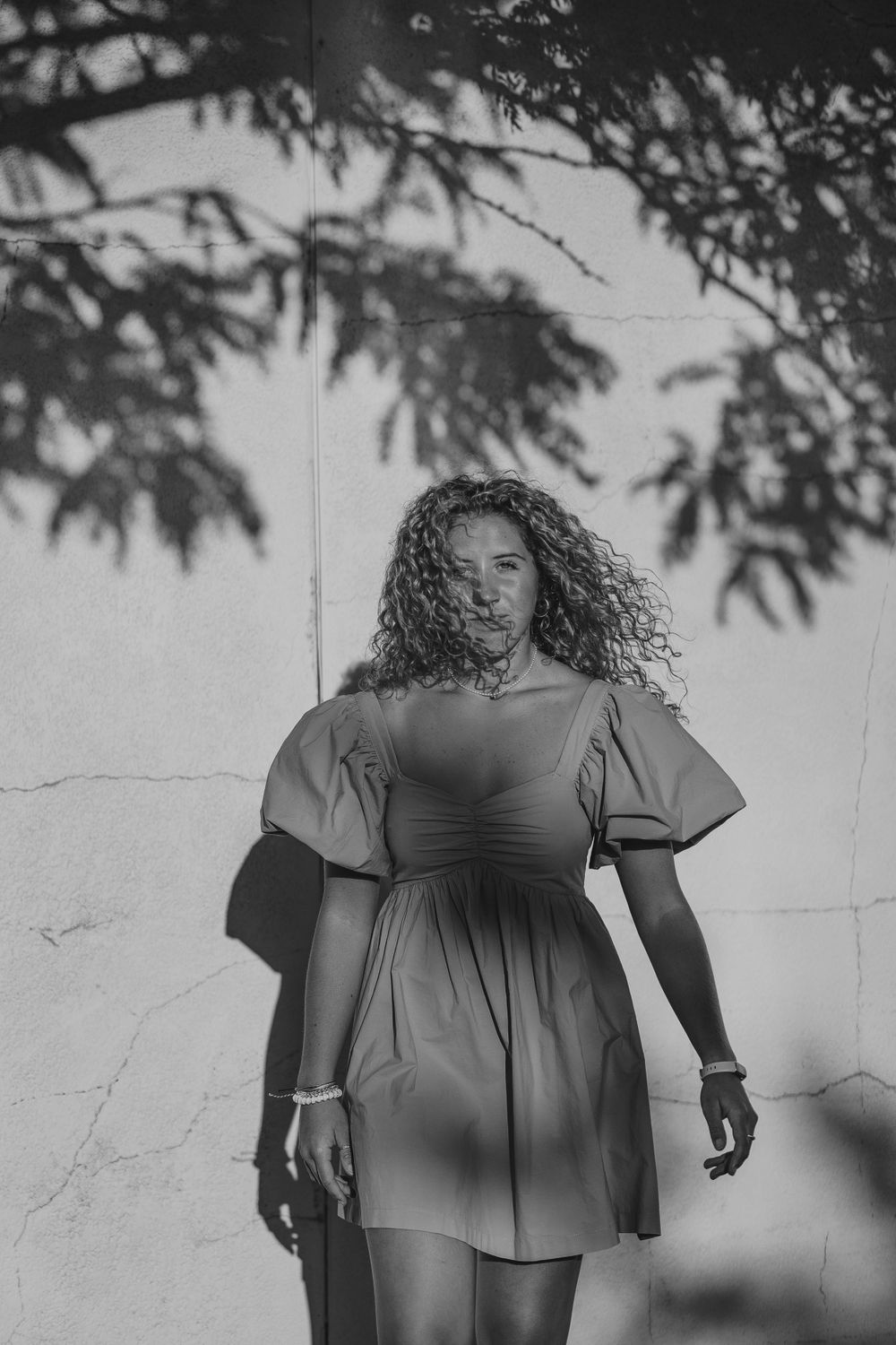 Black and white shadow wall photograph of a senior.