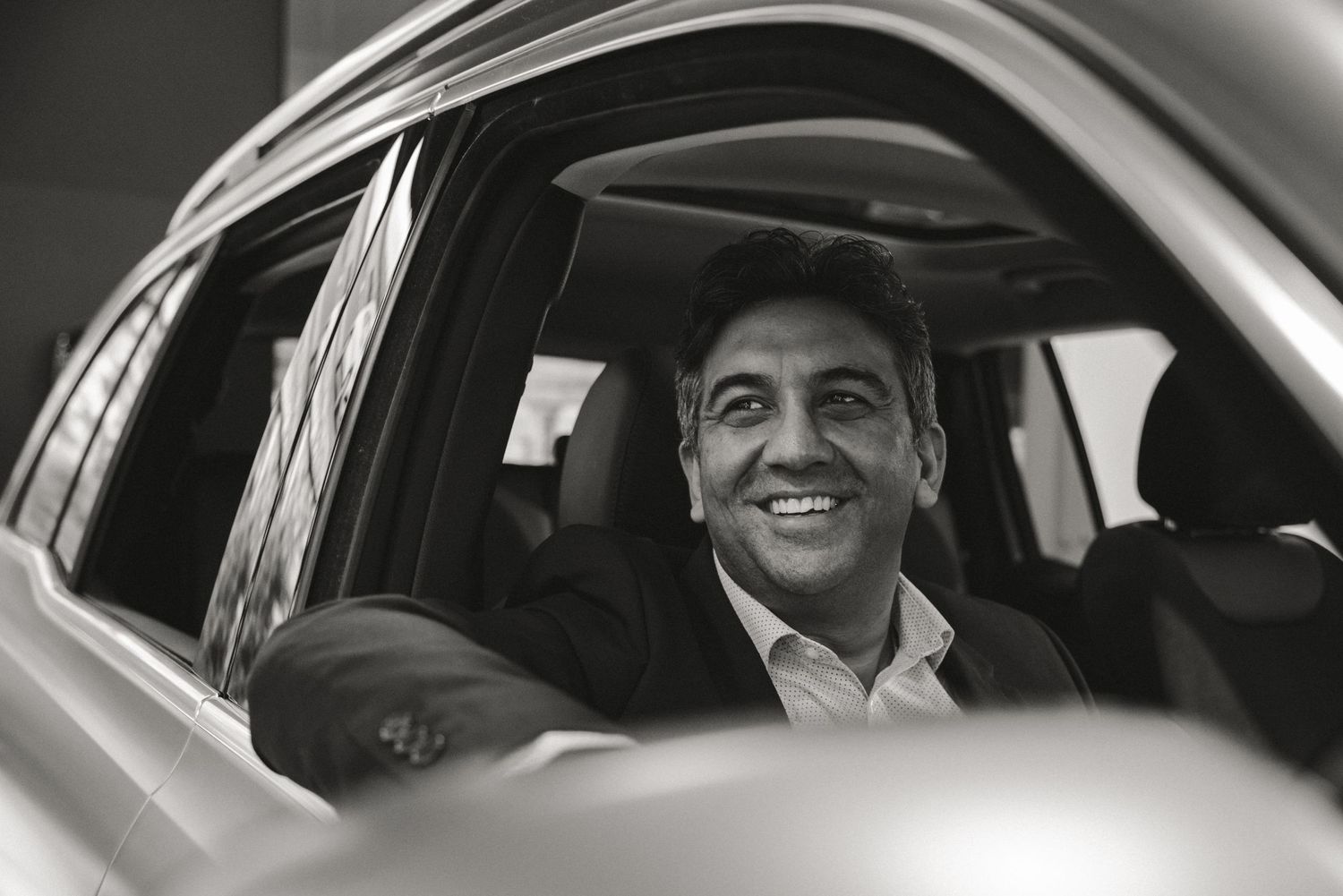 founder man sitting in nice car smiling