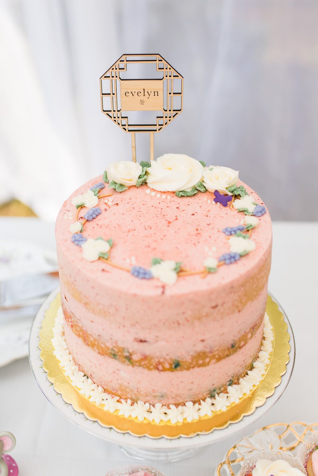 Pink birthday cake with white buttercream roses