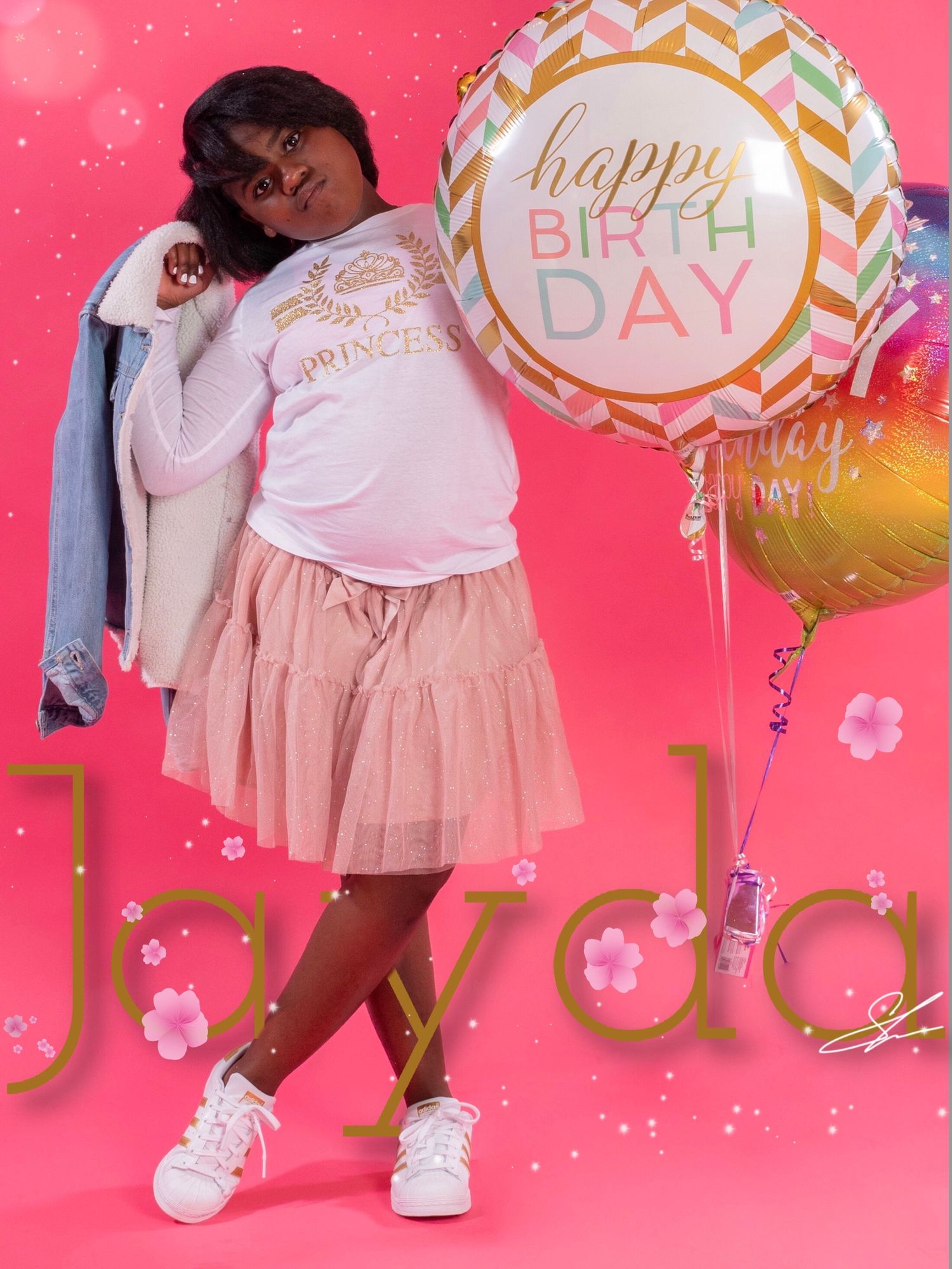 Child in pink tulle skirt poses with birthday balloons against pink backdrop with sparkly effects.