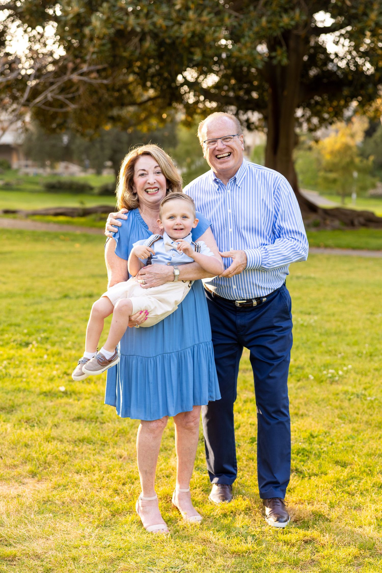 Happy family moment captured in a sunny park setting.