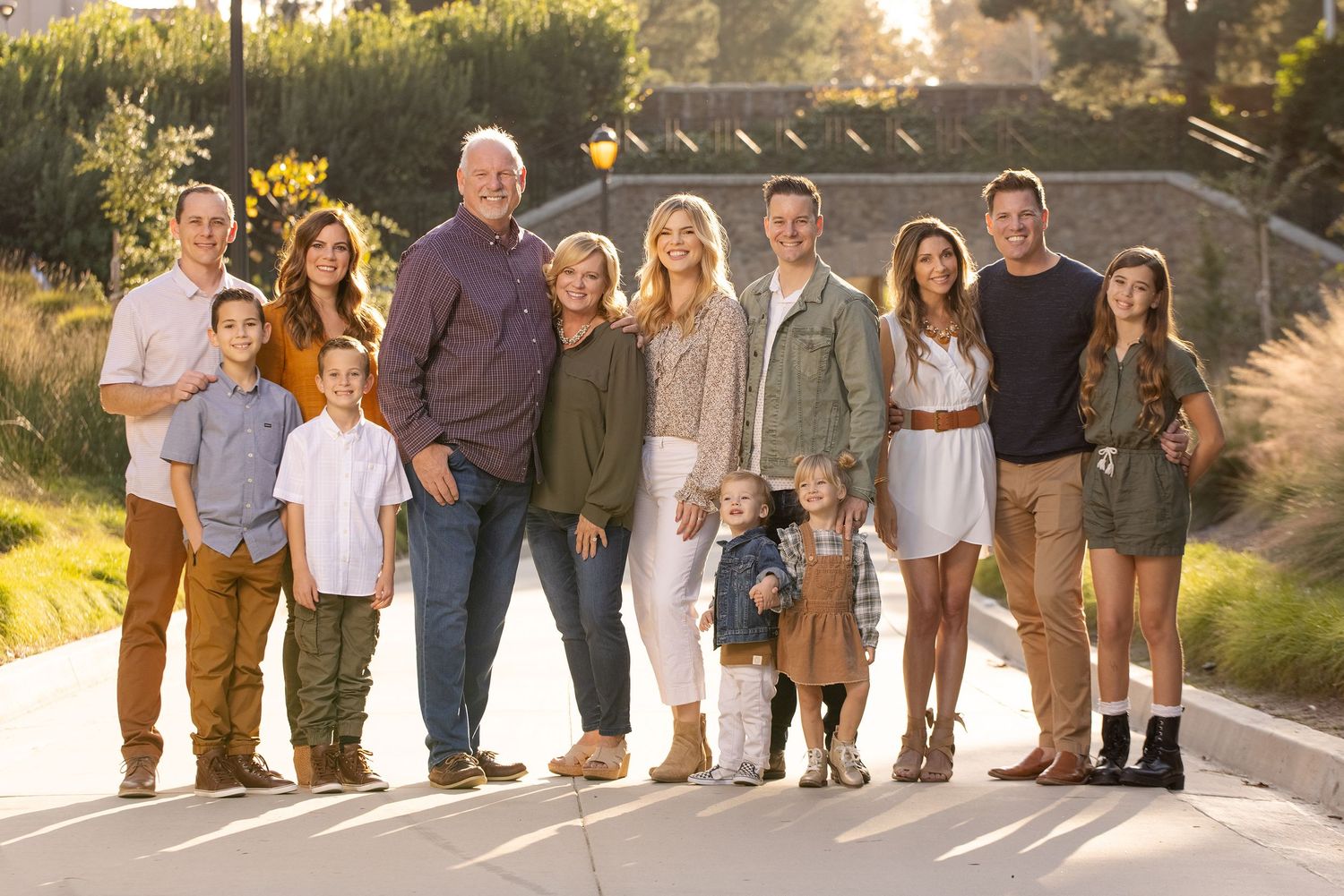 Extended family group portrait outdoors during golden hour lighting.