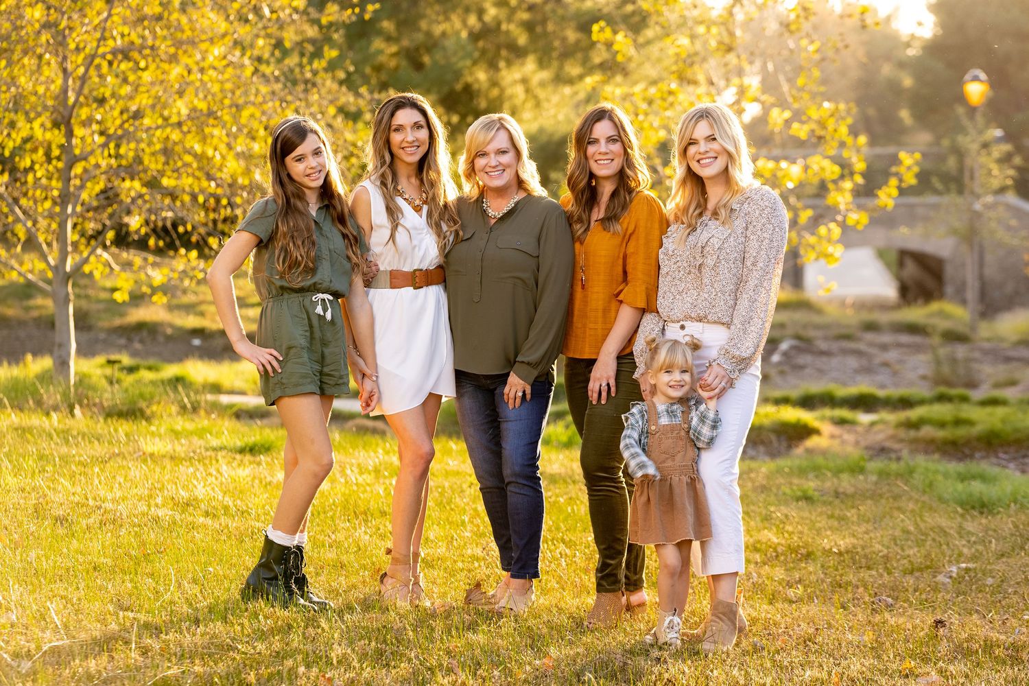 Group poses in casual autumn outfits against golden foliage backdrop.