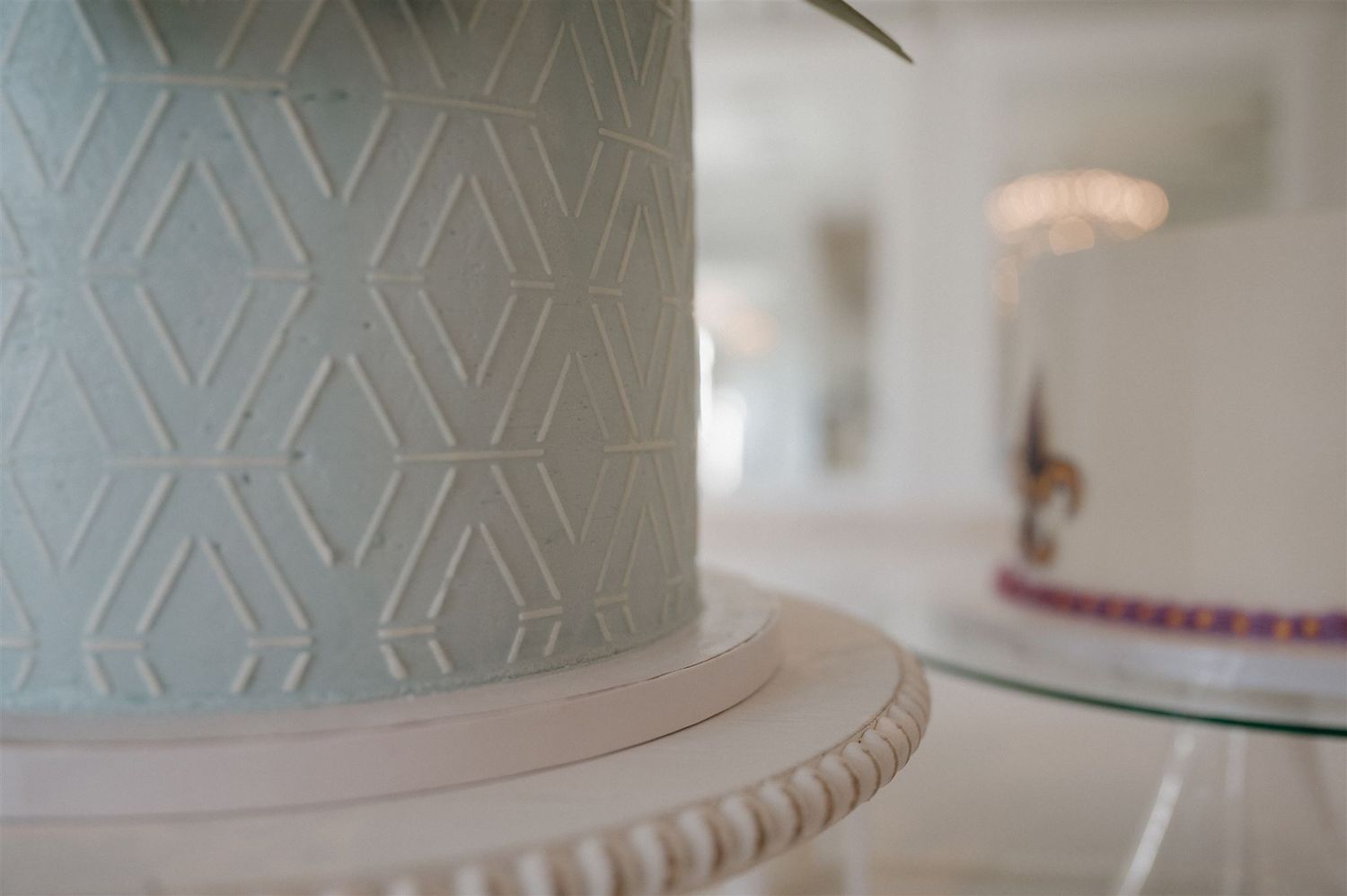 Close-up detail of geometric pattern on light blue wedding cake tier.