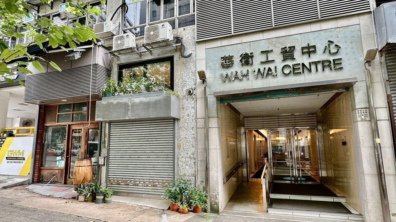 Urban street scene showing industrial building exterior with closed metal shutters.