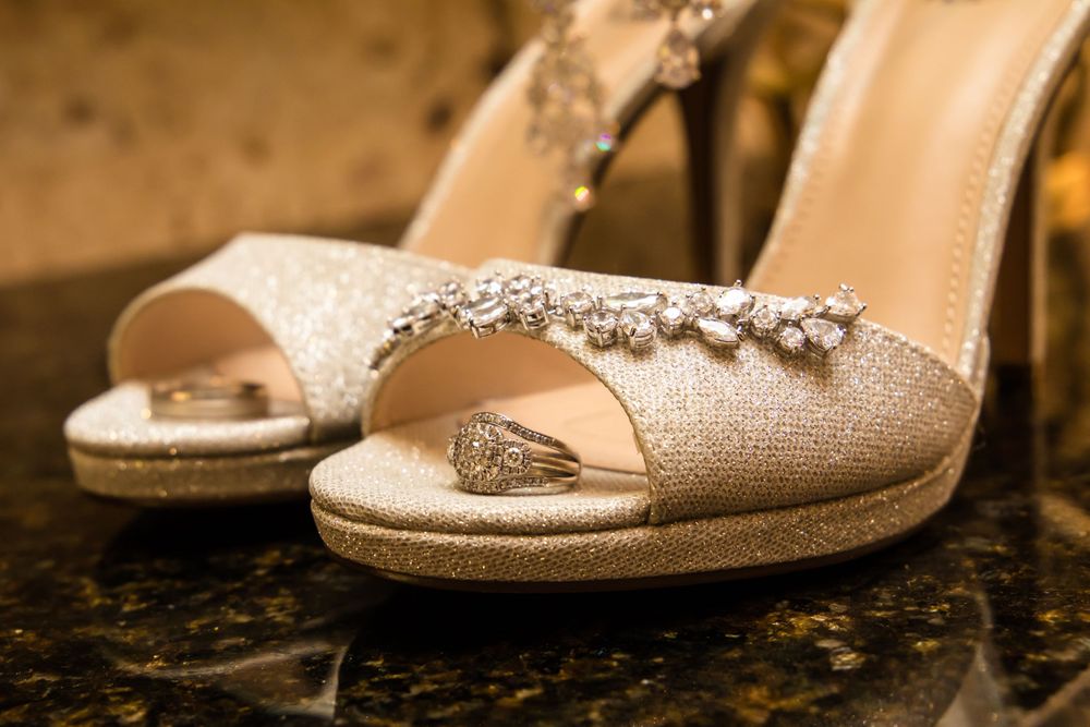 Close-up of sparkly wedding shoes with rhinestone details in golden lighting.