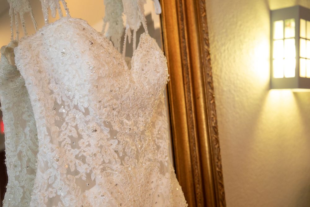 Close-up details of an ornate white wedding dress with intricate lace patterns.