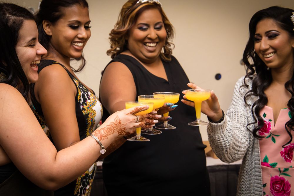 Friends sharing drinks and laughter during a celebration event.