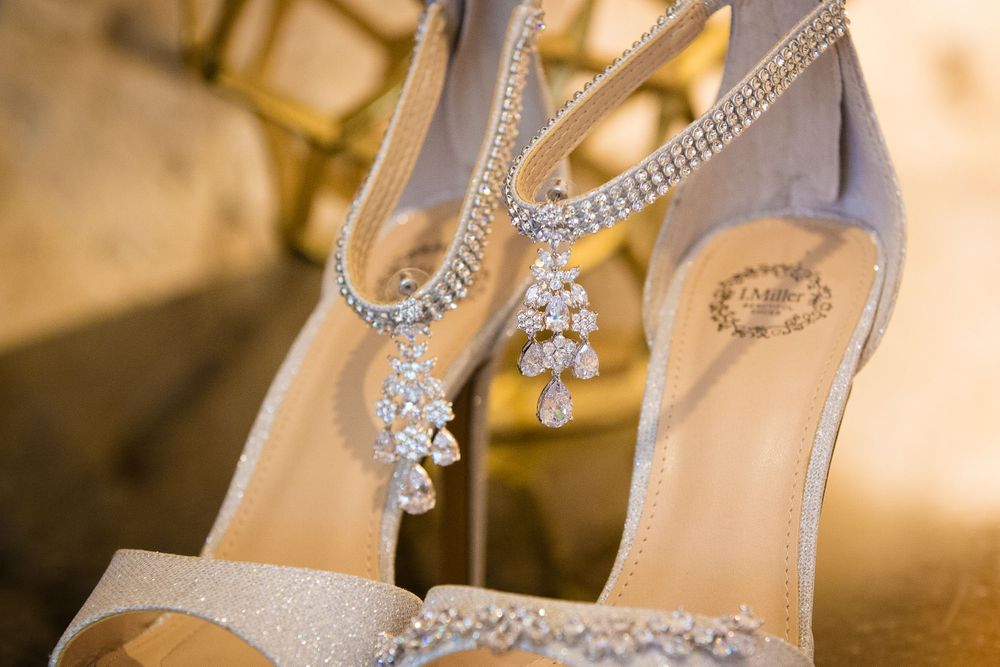 Elegant bridal shoes with crystal embellishments displayed against warm lighting.