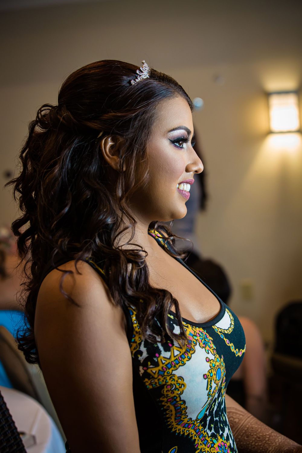 Side profile view of someone wearing an elegant teal and gold patterned dress.