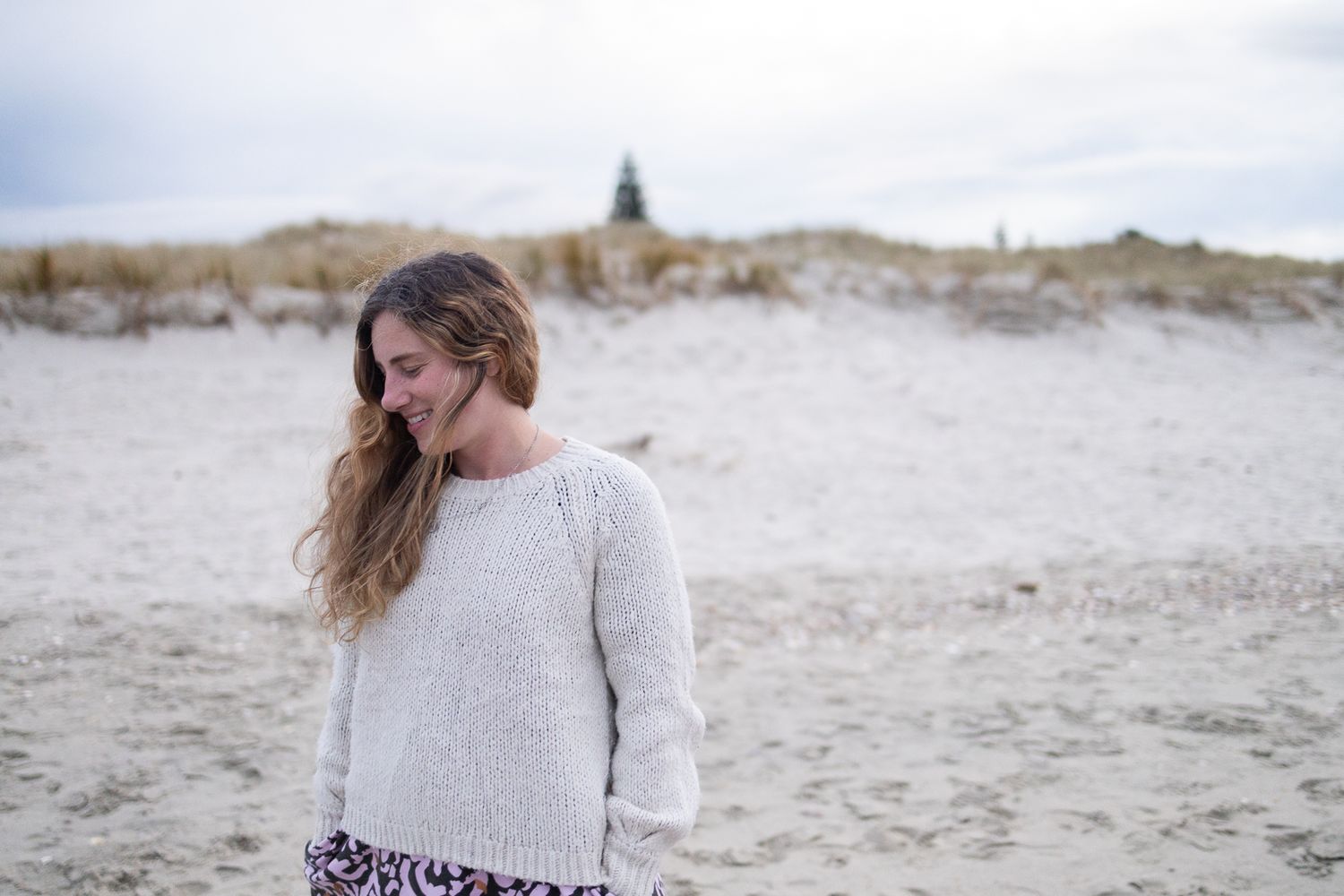 Documentary photographer AnnMarie Dawn posing candidly on Omaha Beach, New Zealand.