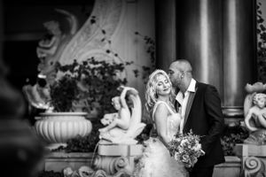 Intimate black and white wedding portrait with decorative garden elements.