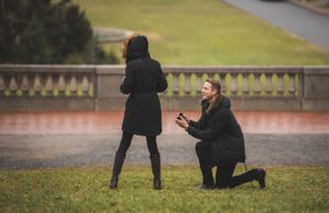 A surprise marriage proposal moment captured on a misty day in a garden setting.