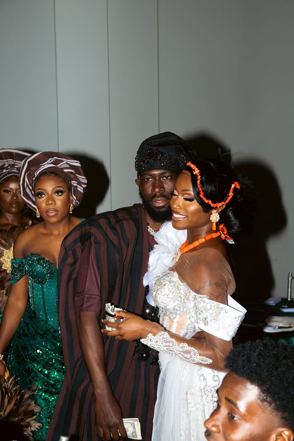 Wedding celebration with guests in traditional African dress and formal attire posing for photos.