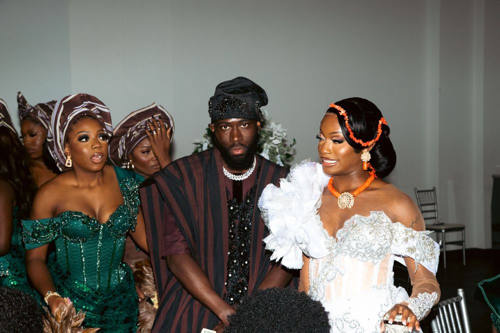 Wedding party members in coordinated outfits of emerald green and burgundy posing together.