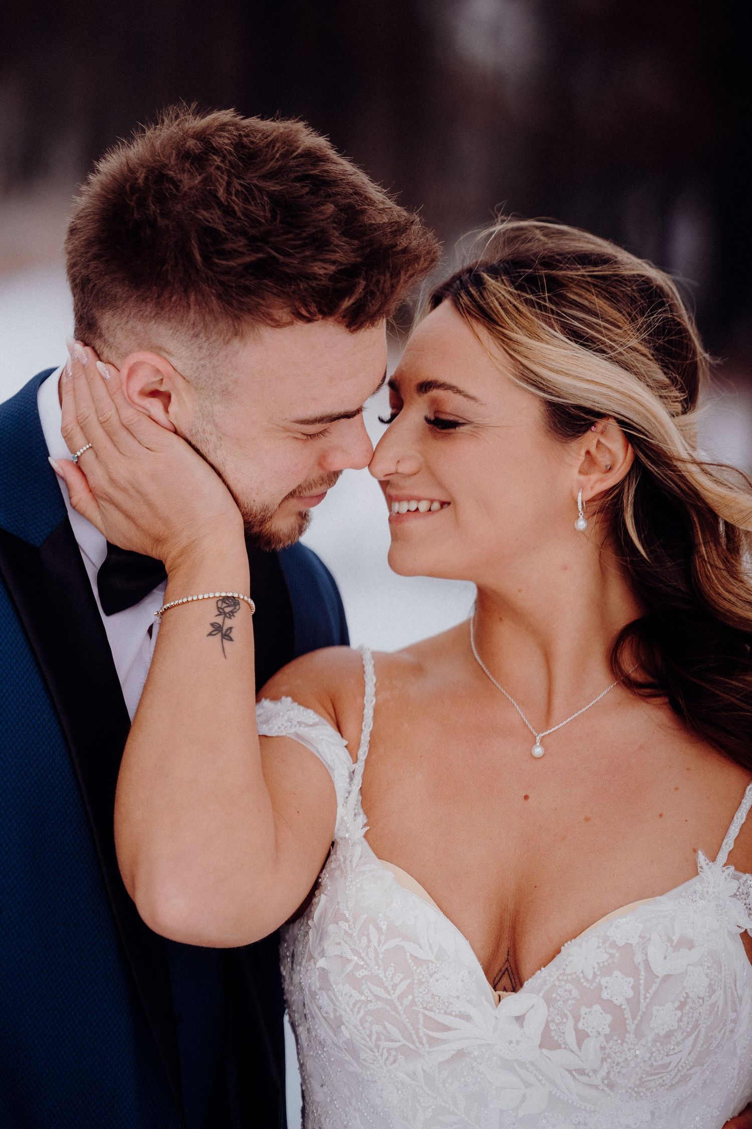 A tender close-up moment between newlyweds in formal wedding attire.