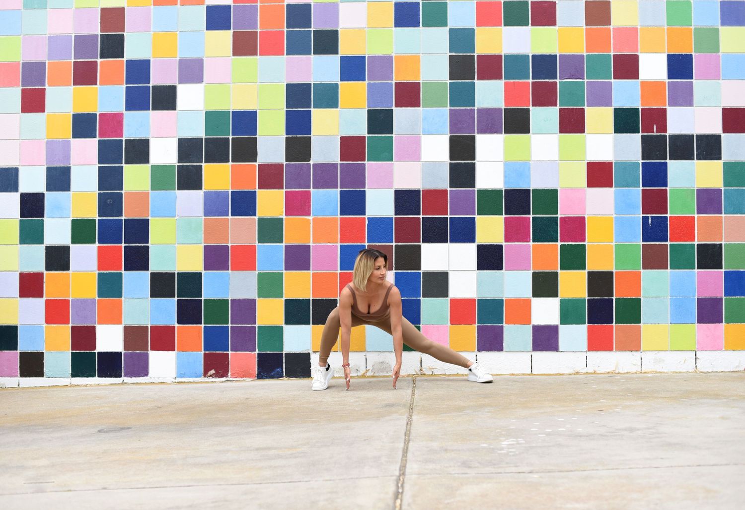 A colorful mosaic tile wall provides a bright backdrop for two people posing.
