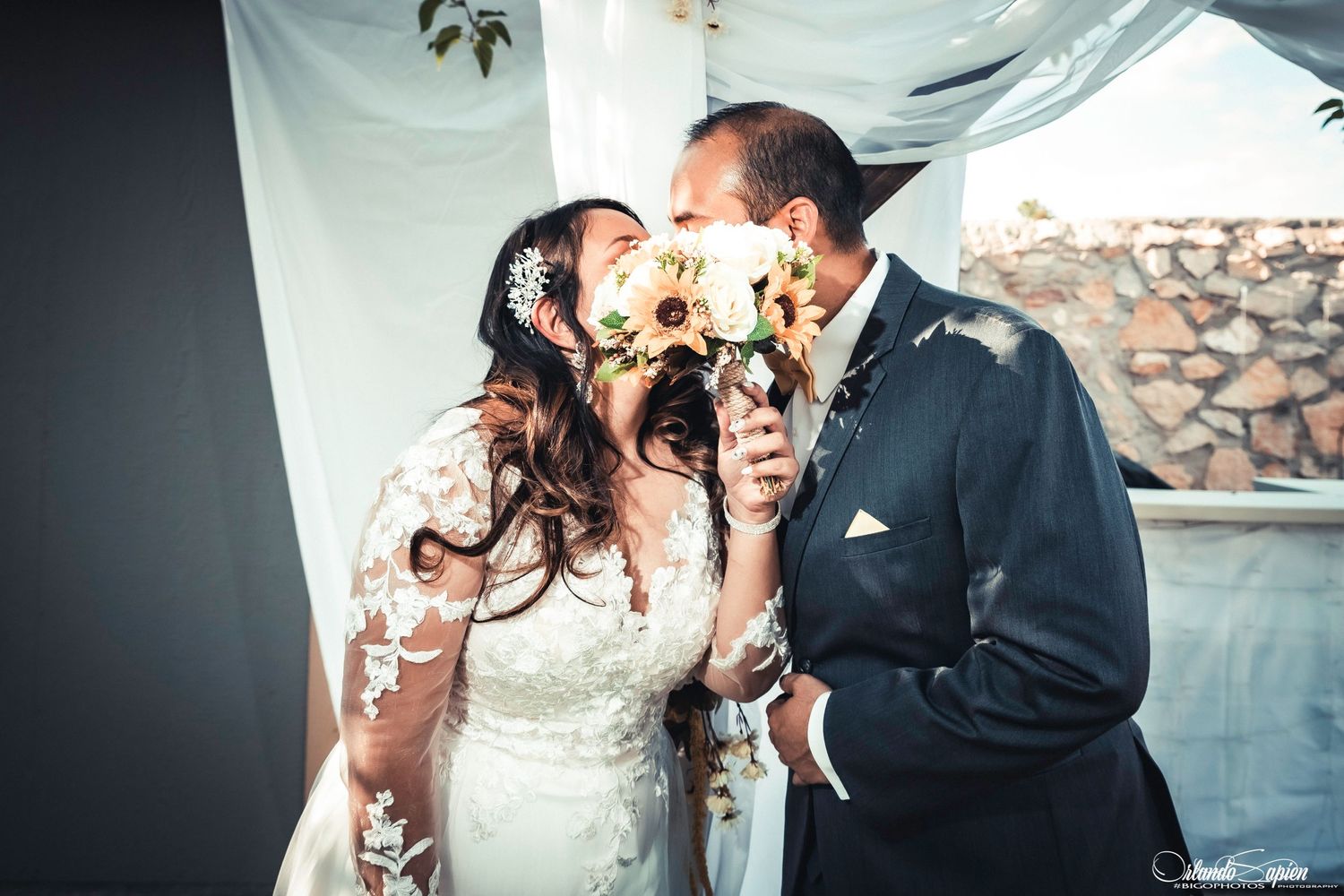 Romantic wedding couple sharing an intimate moment against a white backdrop.