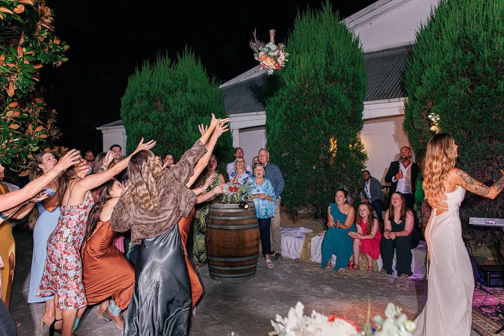 Guests dancing and celebrating at nighttime outdoor wedding reception.