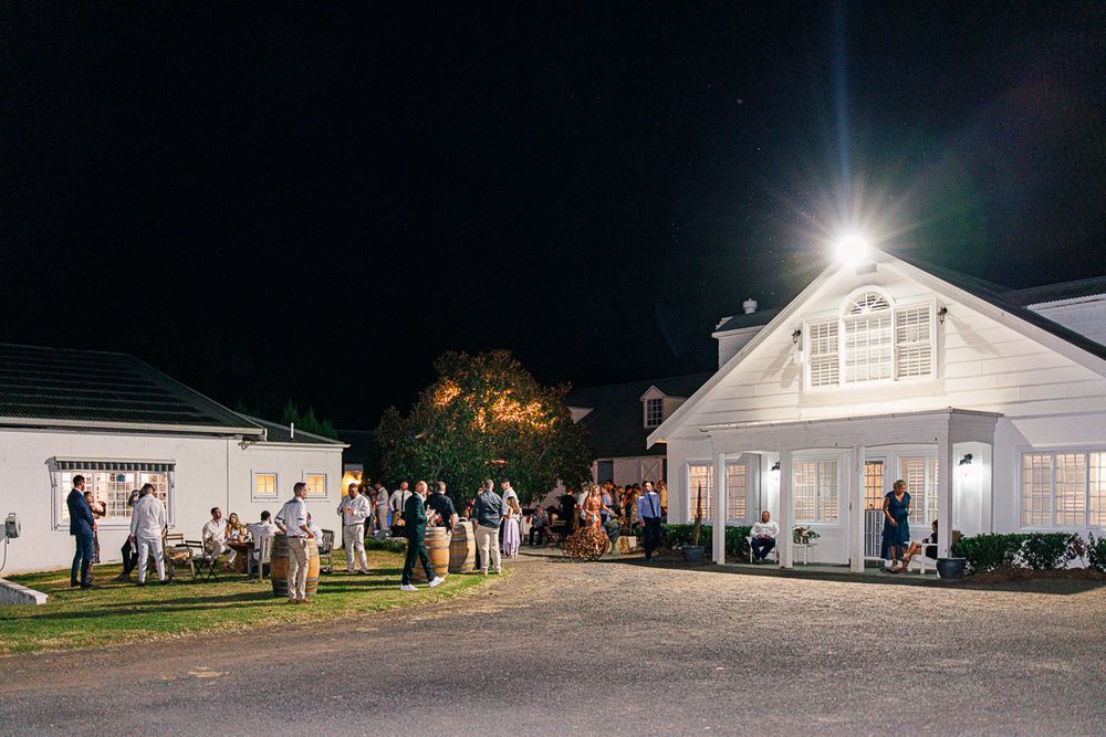 Panoramic view of white wedding venue buildings illuminated at night.
