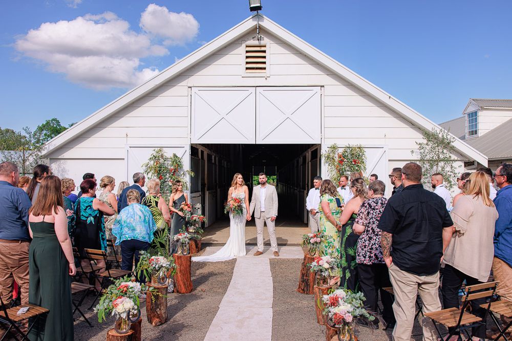White barn wedding venue with rustic decor and floral arrangements.