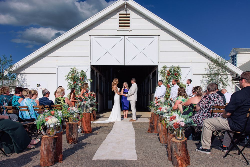White barn wedding venue decorated with rustic elements and floral arrangements.