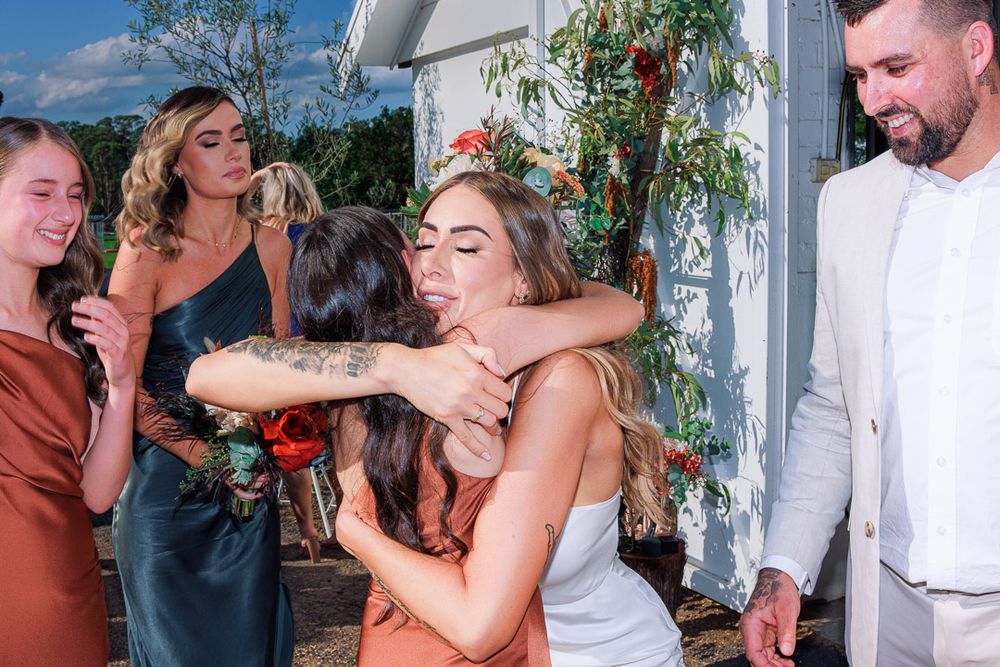 Celebratory moments shared between wedding party members outside rustic venue.