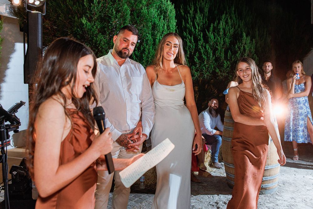 People dancing and celebrating at a nighttime outdoor party with natural greenery backdrop.
