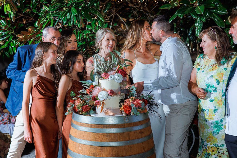Guests gathered around a rustic wine barrel during outdoor celebration.