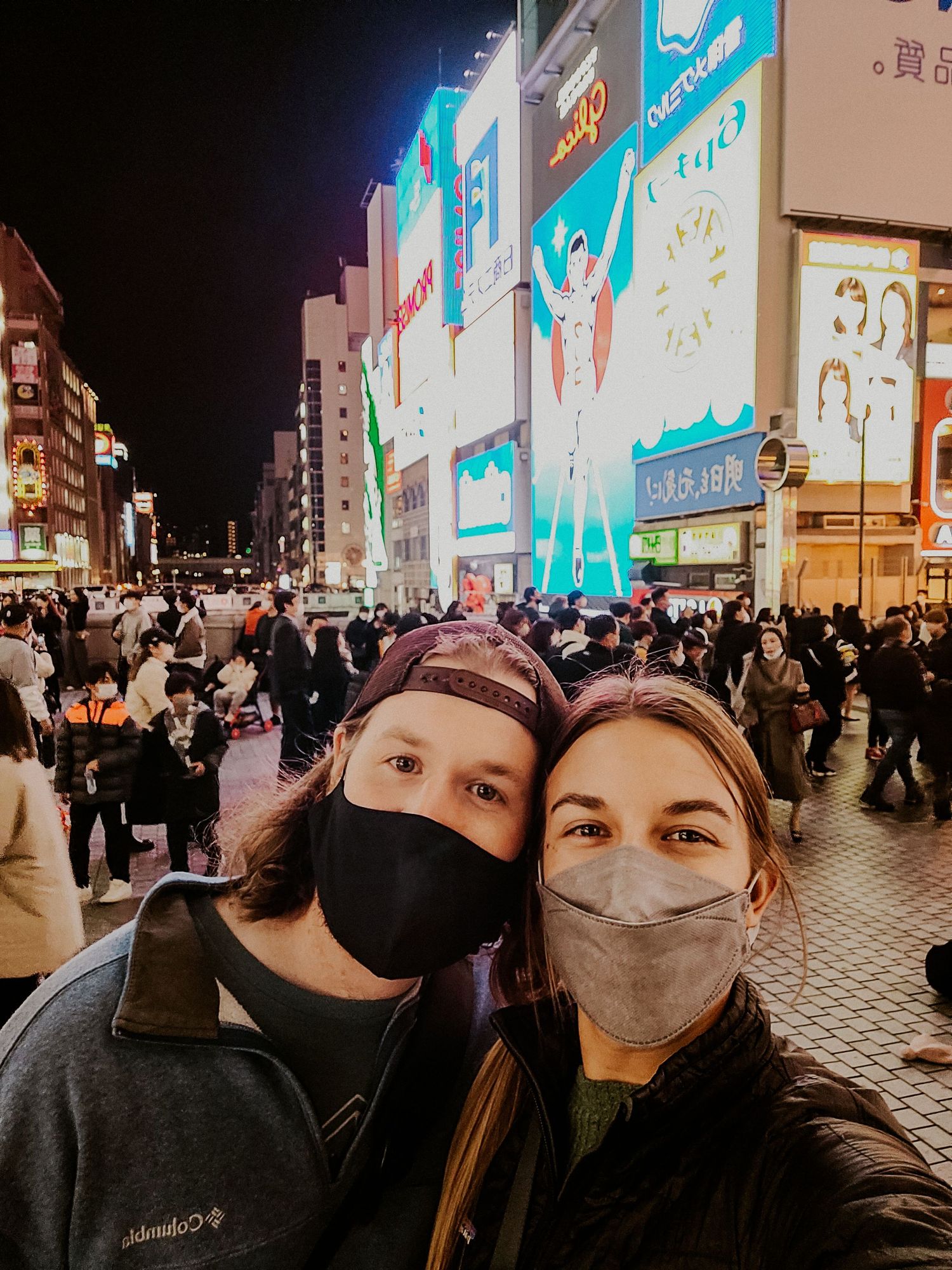 couple smile for photo in the streets of Osaka, Japan