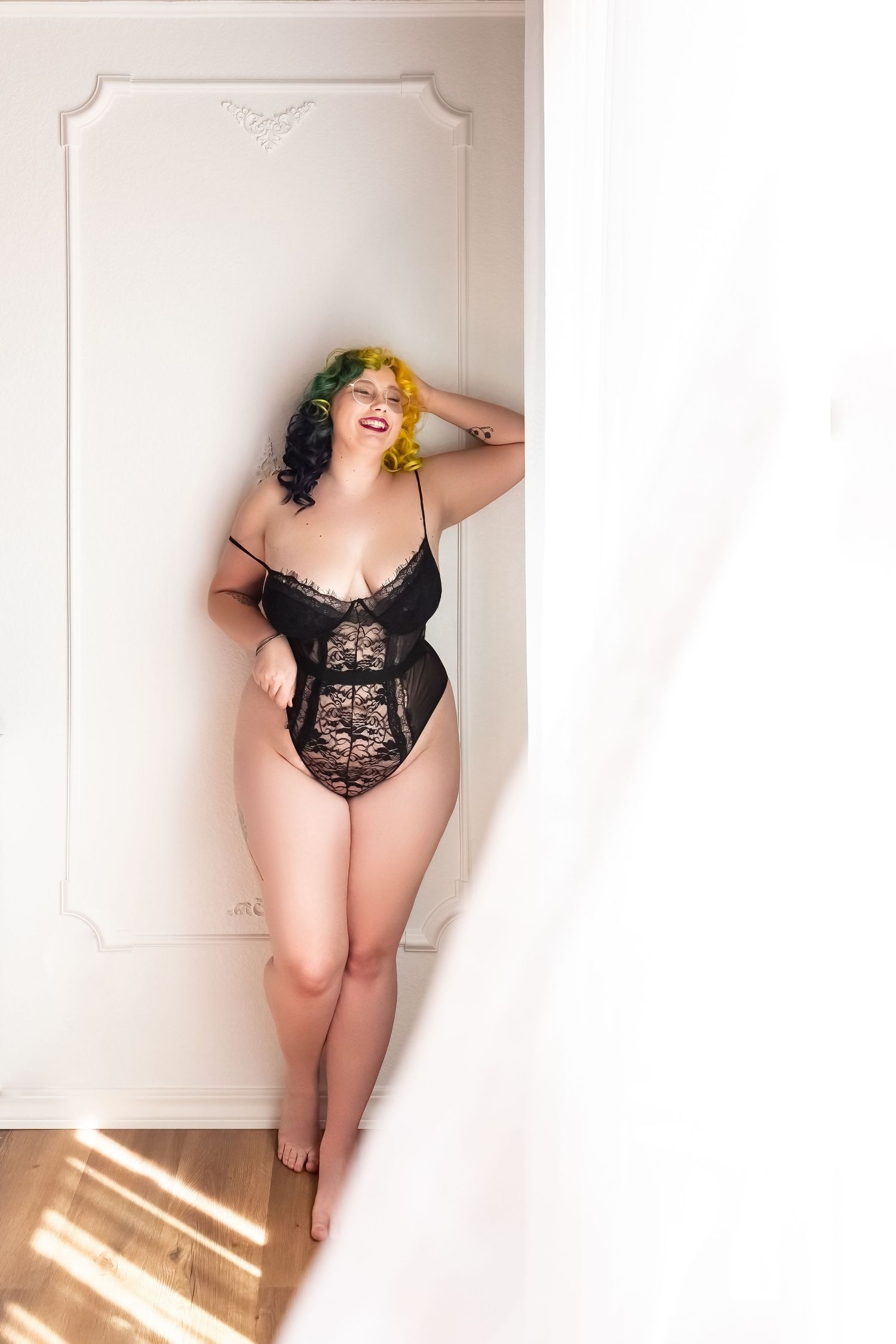 Woman with red lips laughing in black lingerie - The best boudoir photography studio in Colorado Springs