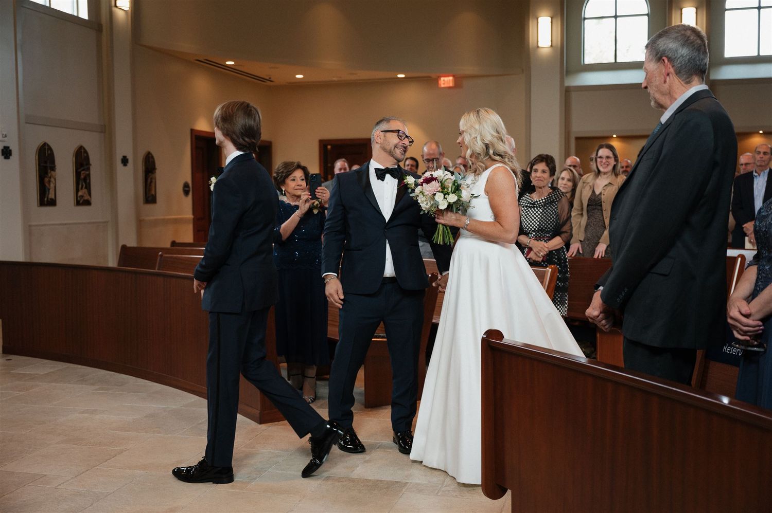 Wedding celebration with guests and couple in traditional church setting.