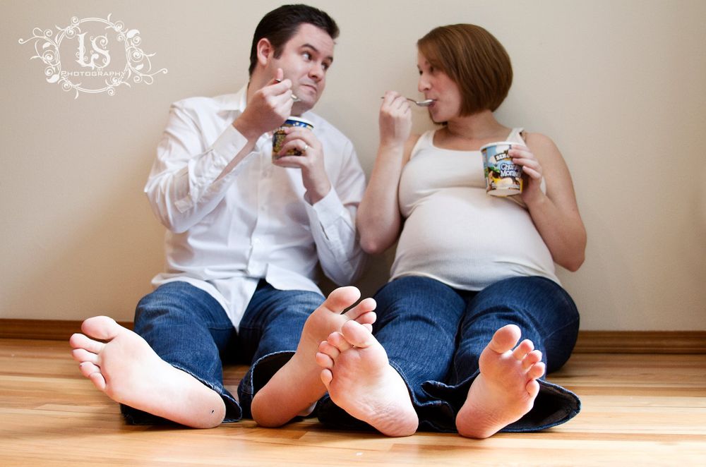 Casual maternity photos showing couple sitting on floor in relaxed poses.