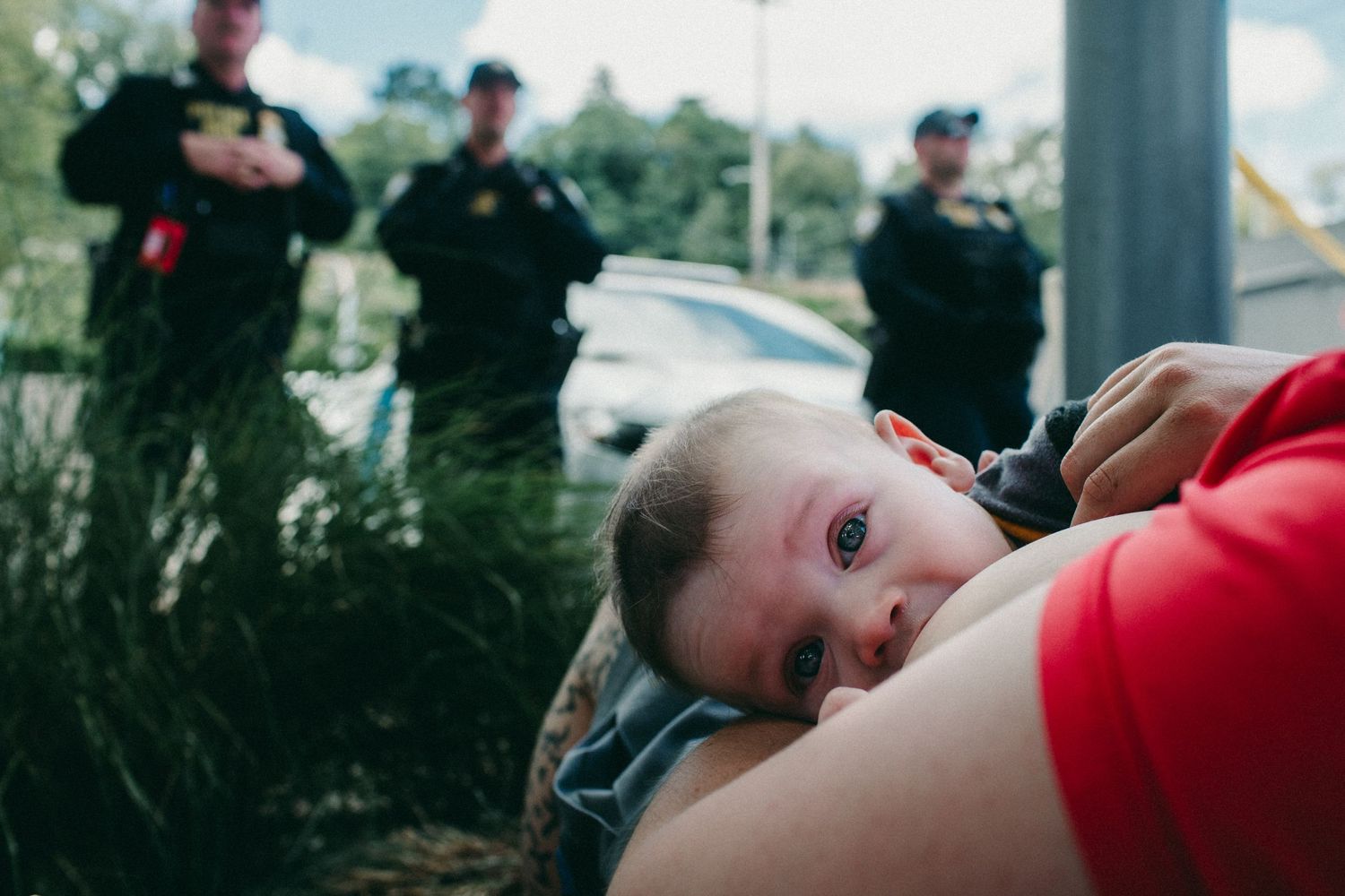 infant being chestfed by parent on police line outside ICE building portland oregon photojournalism