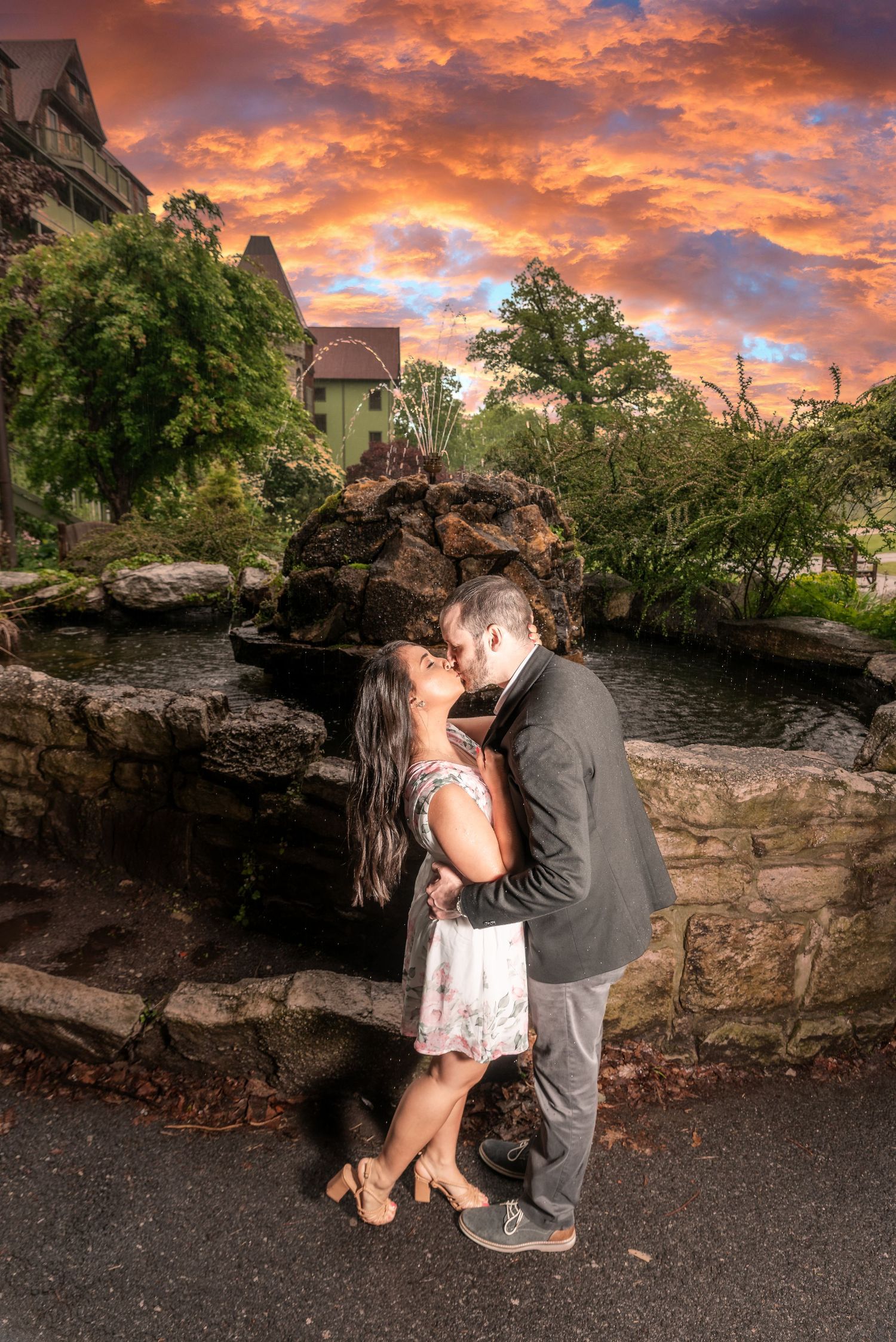 man and woman kissing underneath a fiery sunset
