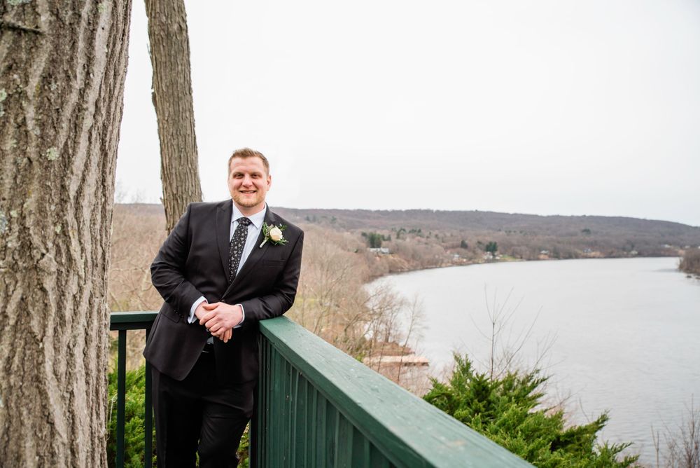 Scenic wedding venue view overlooking a river and mountains from a deck railing.