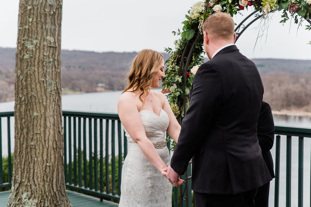 A wedding ceremony moment captured on a deck overlooking a scenic winter landscape.