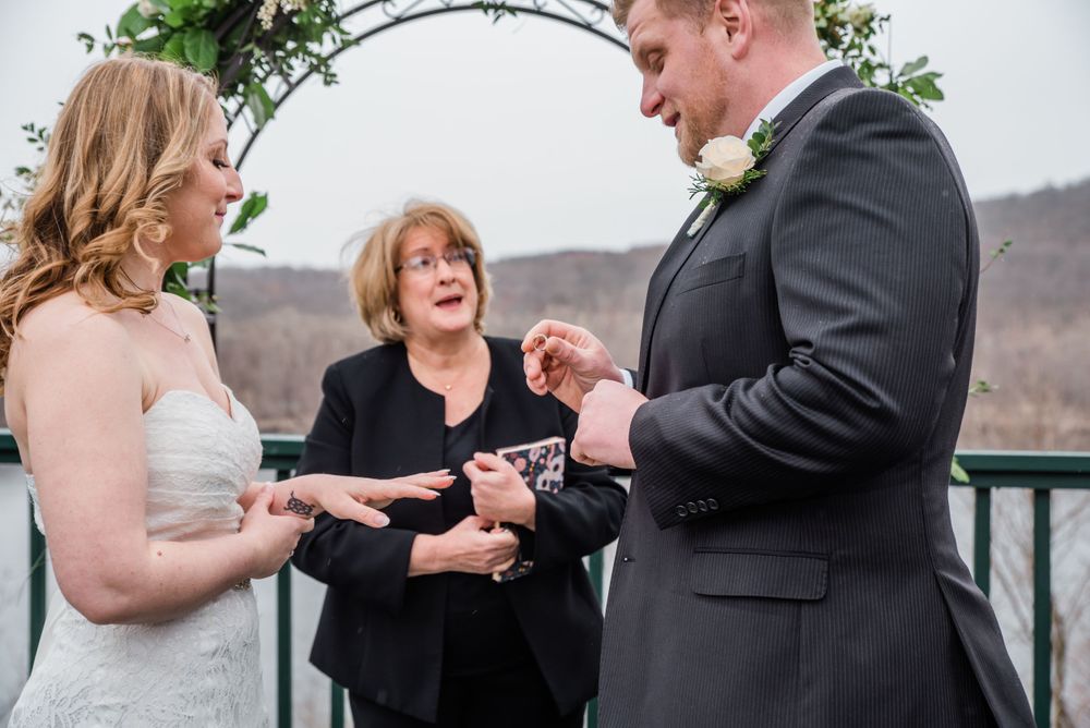 Joyful moment during ring exchange at outdoor wedding ceremony.