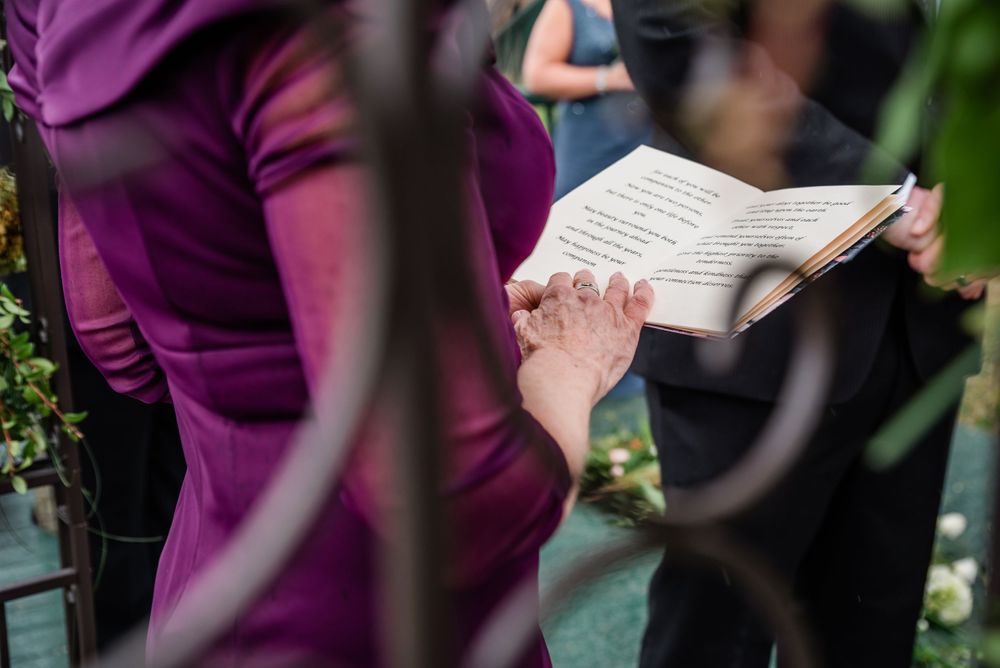Close-up of wedding ceremony book being held in purple dress.