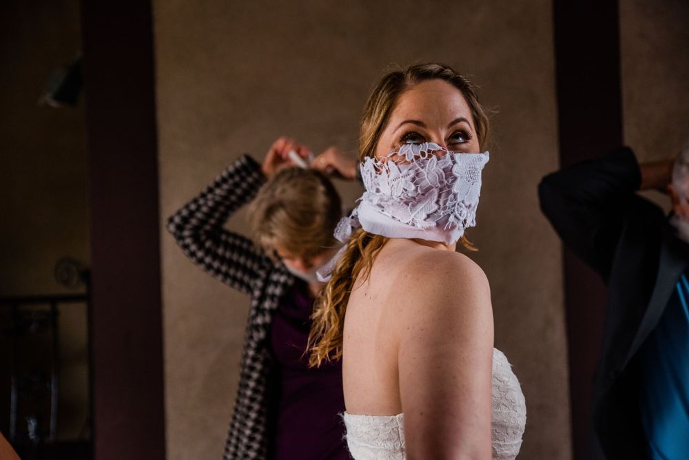 A wedding celebration with guests wearing protective face masks during an indoor gathering.