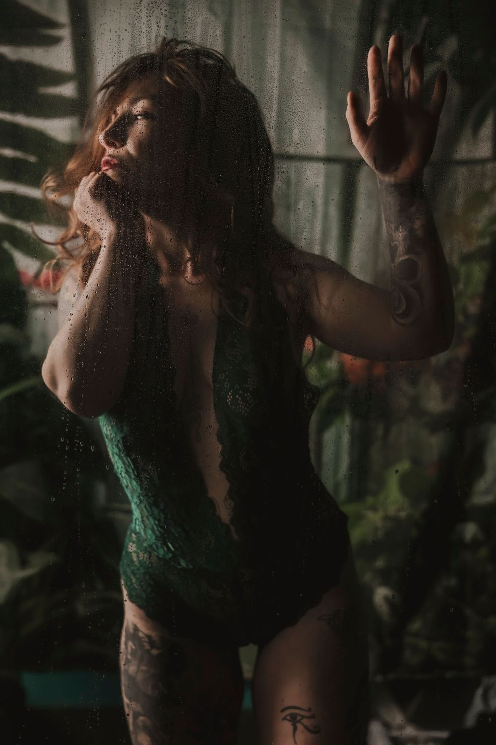 Atmospheric portrait showing silhouette in green bodysuit against textured backdrop.