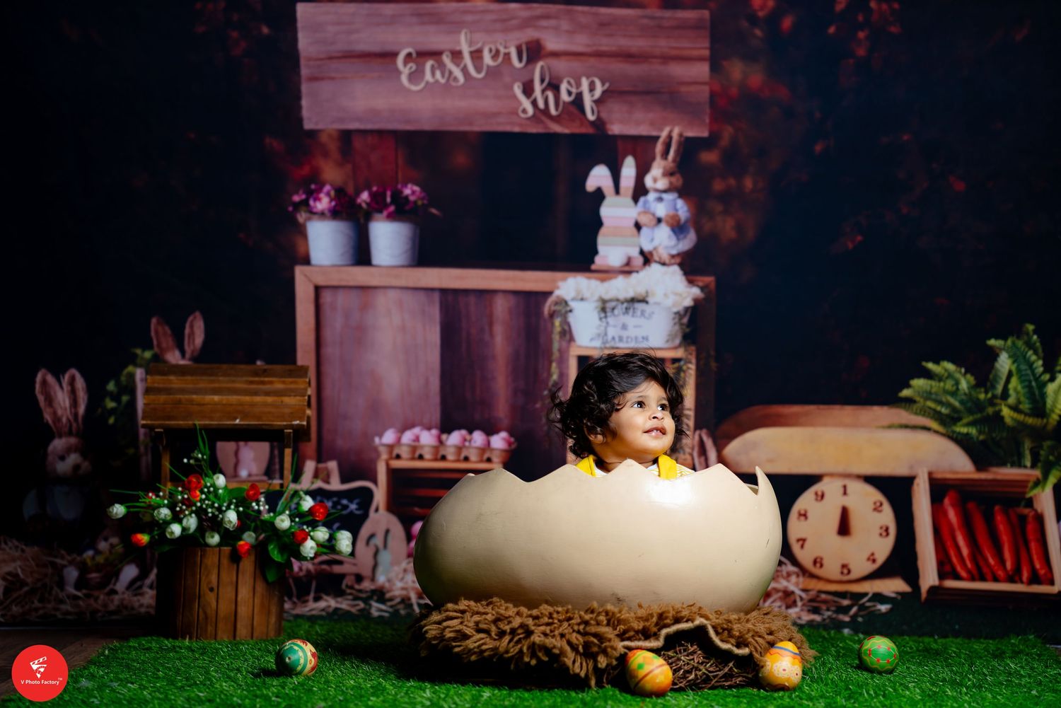Creative Easter-themed baby photoshoot with rustic backdrop and bunny decorations.