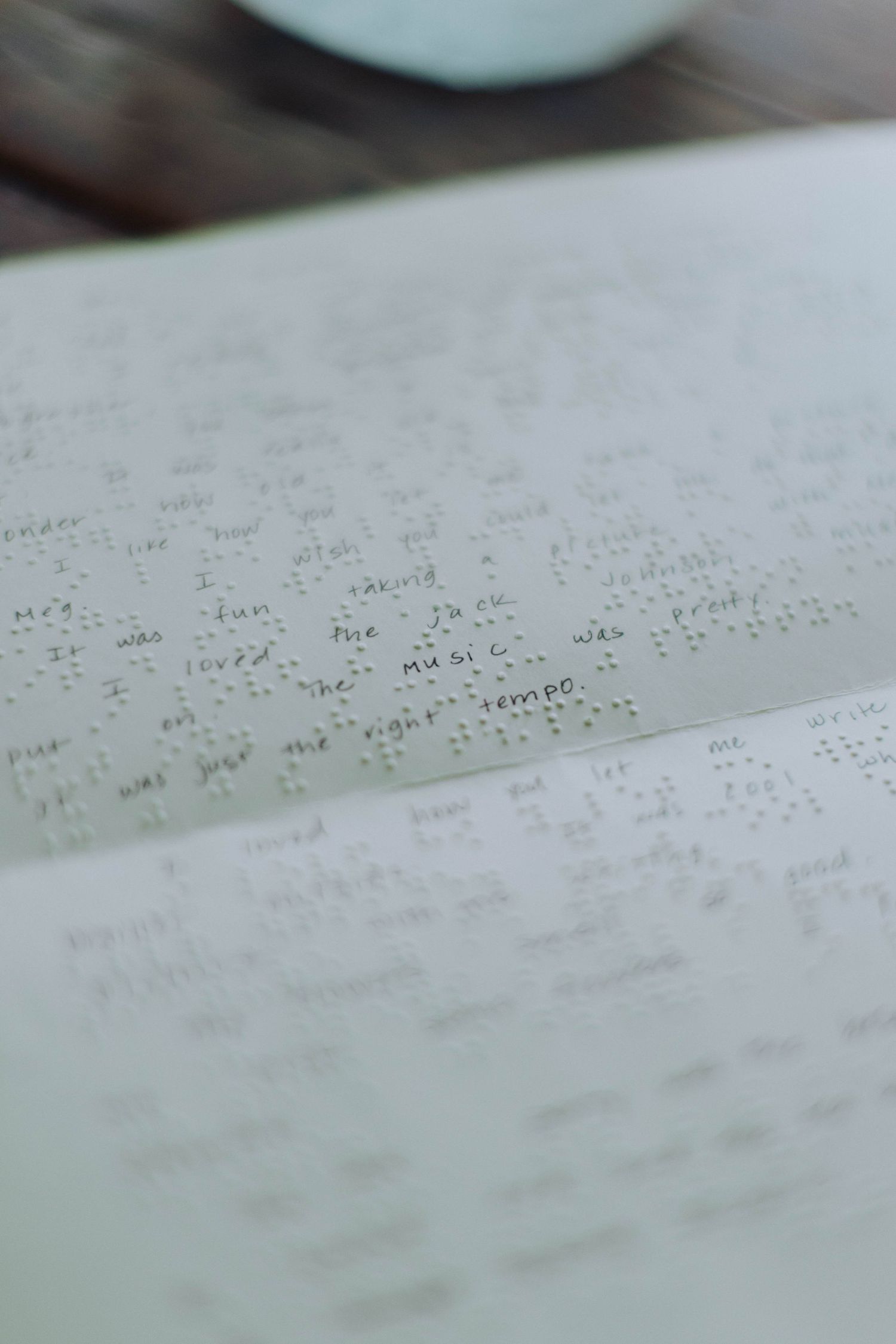 Close-up view of braille text embossed on white paper.