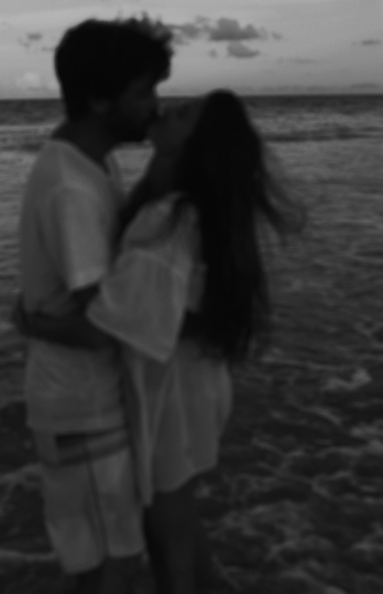young couple kissing cinematically in front of the sea
