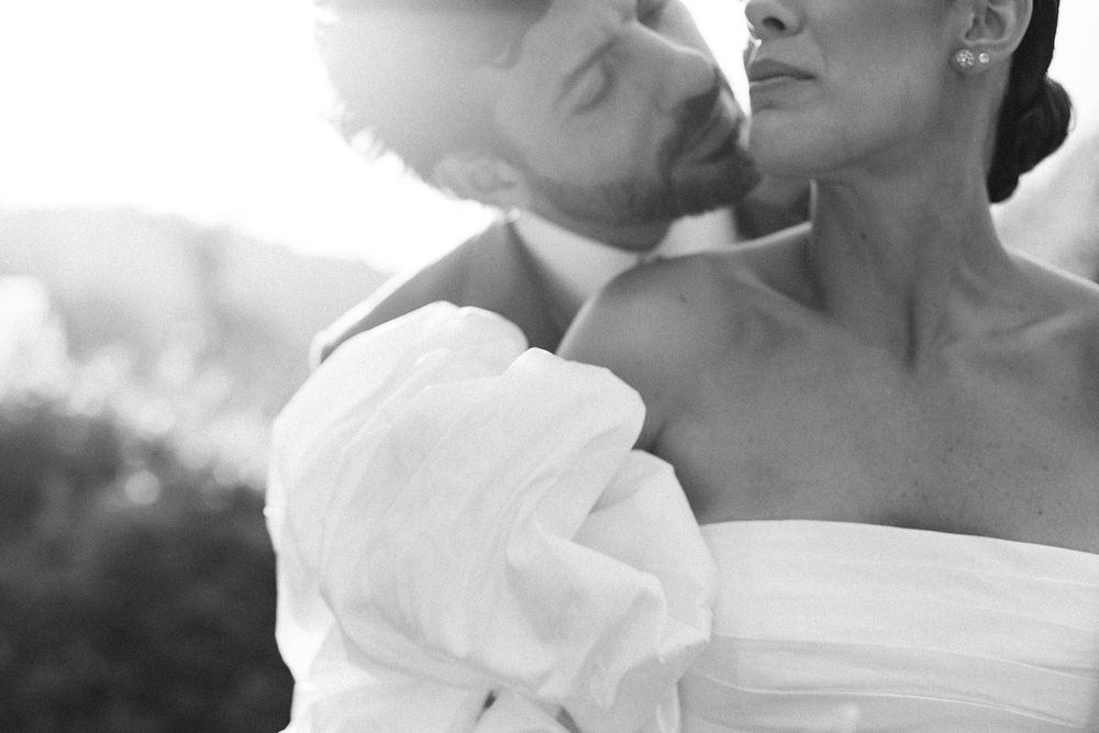 An intimate black and white portrait captures a romantic wedding moment.