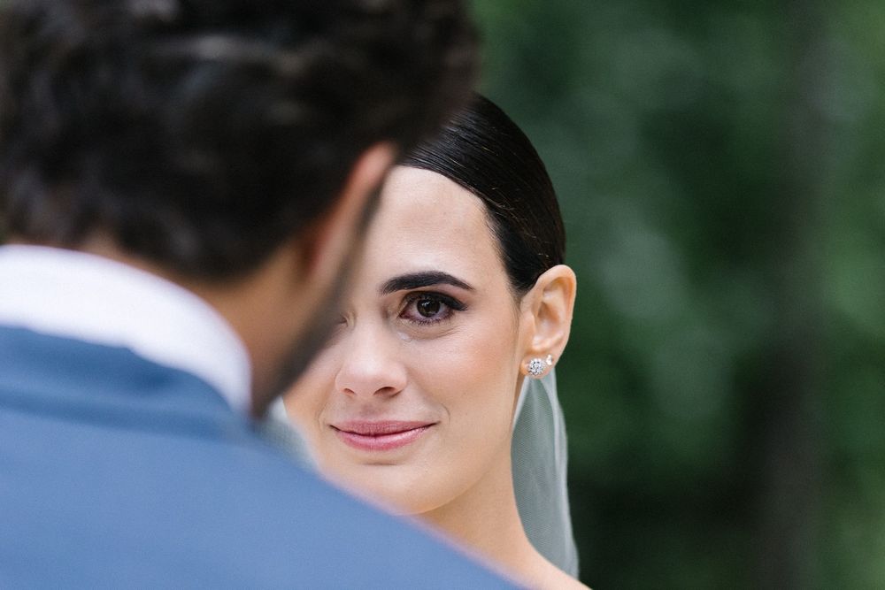 A romantic wedding moment captured between newlyweds with soft natural lighting and greenery in background.