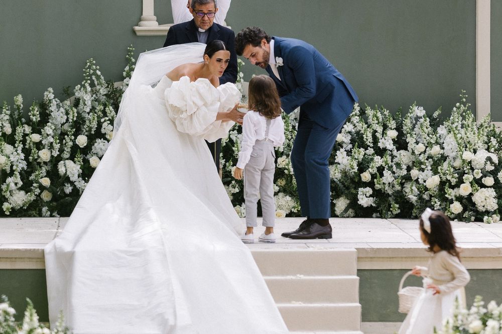A wedding celebration on a stage decorated with white flowers as attendees share a joyful moment together.