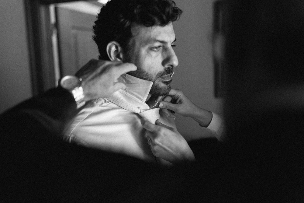 Black and white photo of a person getting their neck shaved during a barbershop grooming session.