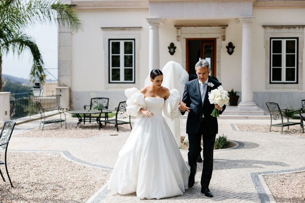 Wedding portrait on sunny terrace of Mediterranean-style villa.